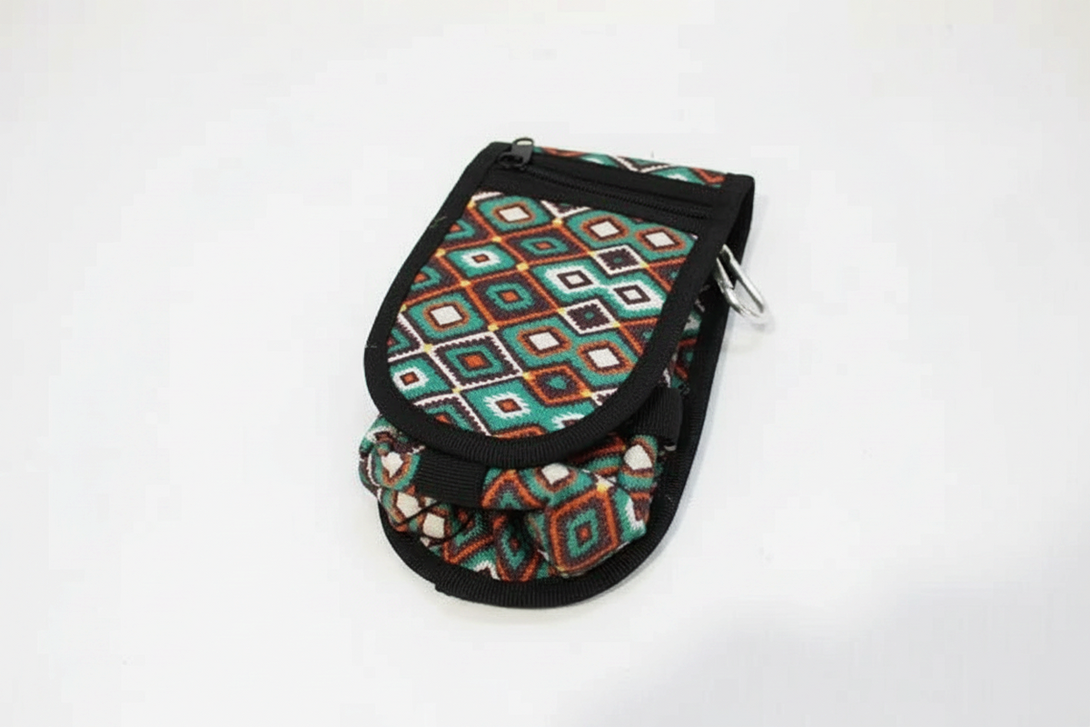 Clarabeths geometric saddle pouch featuring a vibrant multi-colored diamond pattern, zipper closure, and carabiner.